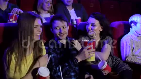 一个年轻人和两个女孩坐在电影院里调情视频的预览图
