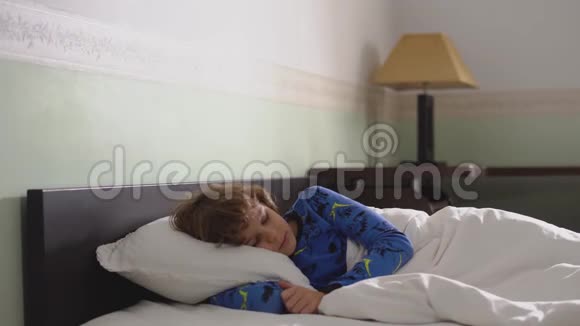 睡在床上的可爱的小男孩安静的睡眠安静的早晨视频的预览图