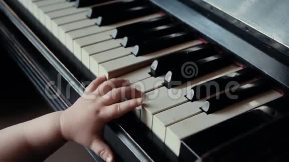 小可爱的小男孩在不确定的情况下缓慢地按下钢琴键视频的预览图