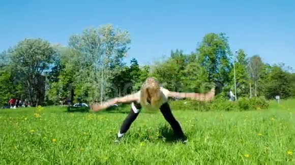 灵活的女孩在大自然中做热身在斜坡上一边一边挥动手臂动作缓慢视频的预览图