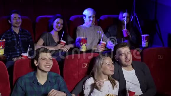 青少年坐在电影院看喜剧吃爆米花喝可乐视频的预览图
