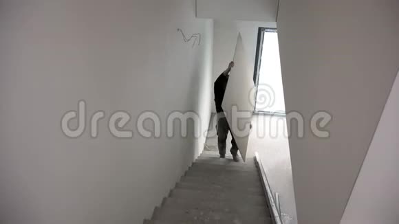 无法辨认的人在楼梯上拿着石膏石膏板视频的预览图
