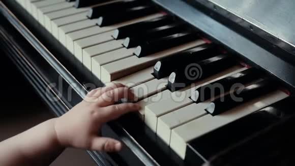 小可爱的小男孩想用双手慢动作弹钢琴视频的预览图
