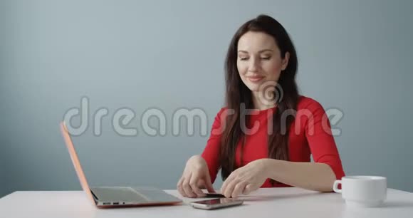 年轻女子在网上购物持信用卡在笔记本前为成功的销售交易拍摄了快乐的镜头视频的预览图