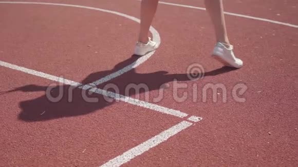 穿着白色运动鞋的运动女性在球场上打网球前做热身运动的腿影子重复着运动视频的预览图