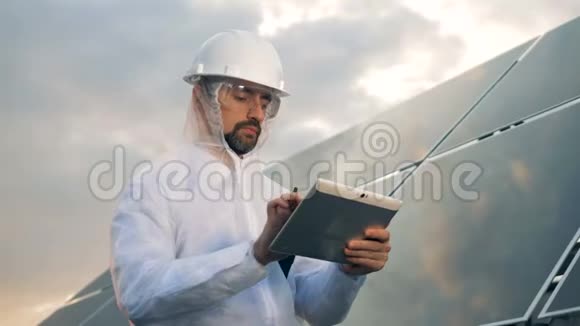 一位工程师在平板电脑上打字站在屋顶上的太阳板附近近距离视频的预览图