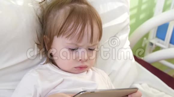 小婴儿看起来像在医院病床上的医疗设施里打电话的卡通医院病房的康复孩子视频的预览图