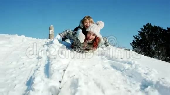 一家人坐雪橇穿过雪地快乐的母子俩坐着雪橇滑下山坡飞快地往下走视频的预览图