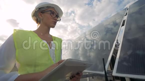 一个女人在平板电脑上打字检查太阳面板关闭视频的预览图