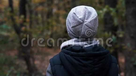 一个男孩走过秋天的森林视频的预览图