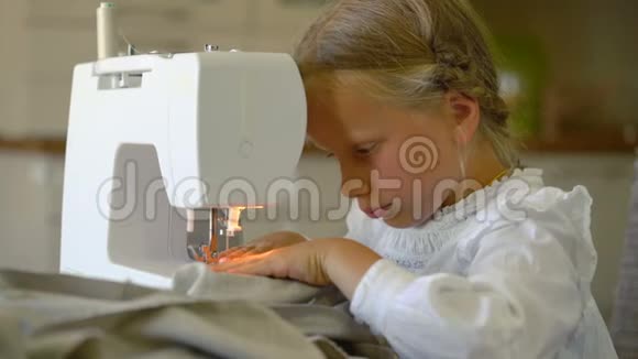 七岁的女孩在家里用缝纫机缝衣服视频的预览图