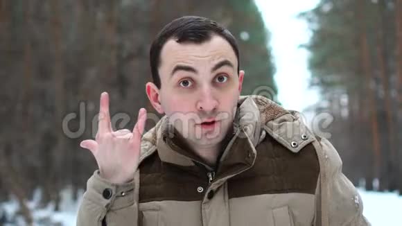 穿着夹克的帅哥的肖像在镜头前展示了成功的姿态人站在冬林中视频的预览图