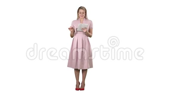 漂亮迷人自信时尚的粉红色女士手里拿着平板电脑看着相机翻页或皱褶视频的预览图