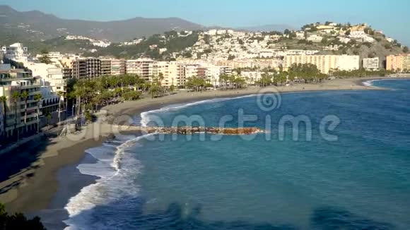 4K电影无人机顶景视频片段拍摄的西班牙海岸城市而绿松石海浪在沙地上破碎视频的预览图