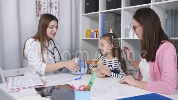 母亲在医生的办公室里给小女儿支持和安慰直到她的女儿戴着口罩视频的预览图