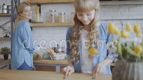 一个小女孩帮她妈妈在家摆桌子女孩们准备吃晚饭4K视频的预览图