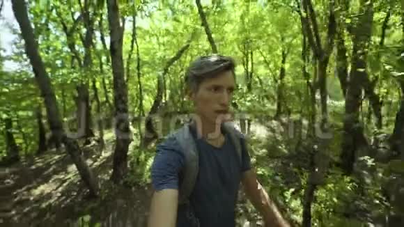 夏日在森林中快速行走的年轻人特写广角自拍视频的预览图