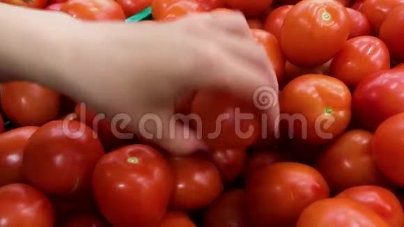女人在超市里选择蔬菜近距离拍摄女性手选美味西红柿视频的预览图