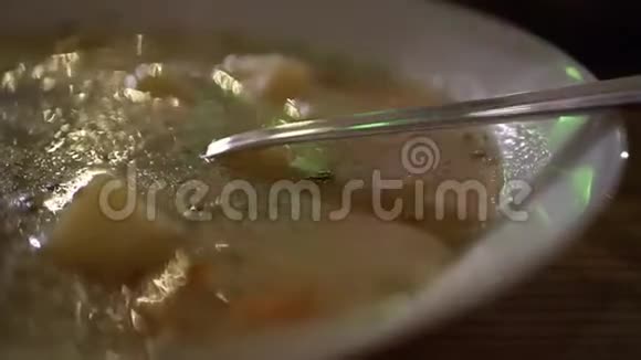 在黑暗的厨房里用金属勺子盛汤盘视频的预览图