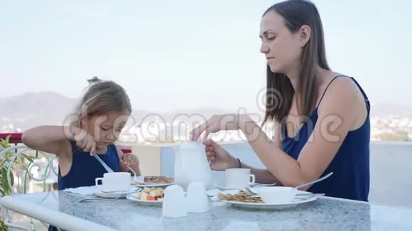 一家人一起在露台上吃早餐这里有美丽的山景视频的预览图