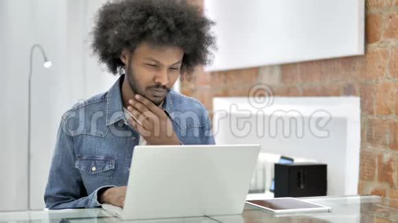 非洲男人在笔记本电脑上工作的思考视频的预览图