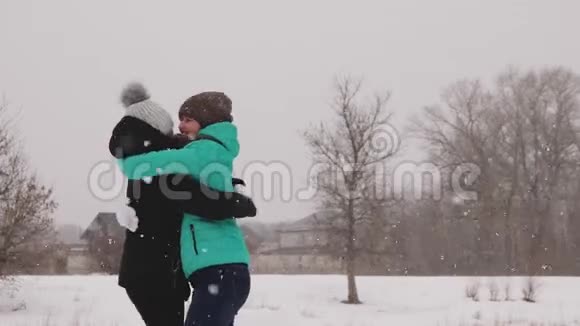 快乐无忧无虑的女孩在雪地公园里欢笑和玩耍女朋友在暴风雪中在街上玩得很开心视频的预览图