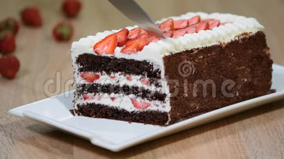 用草莓和鲜奶油切甜的自制巧克力蛋糕特写视频的预览图