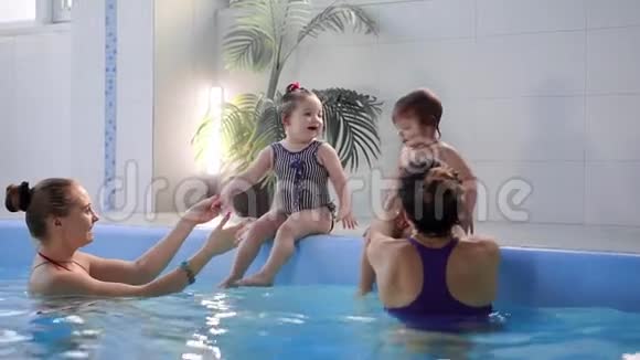 有趣的儿童学游泳的肖像画在蓝色的游泳池里潜水带着乐趣在水下跳着飞溅的水视频的预览图