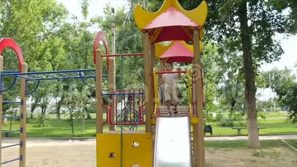快乐可爱的宝宝在户外公园玩那个男孩滚下一座小山动休息和育儿视频的预览图