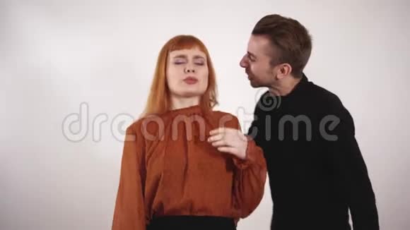 咄咄逼人的男人抓住女人的头发把她的头发拉下来捏着女孩的手大喊大叫女人留着红色的长发视频的预览图