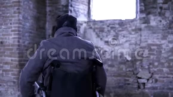 一个坐轮椅的人在一座被毁的教堂里录像一个被遗弃的教堂里的人记忆的概念视频的预览图