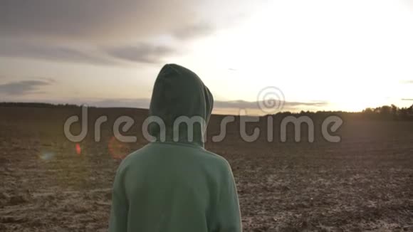 在日落时分在户外的野外散步的头罩男孩视频的预览图