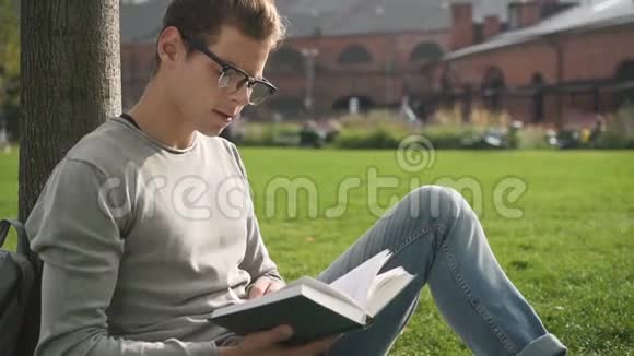 男大学生看书坐校园地视频的预览图