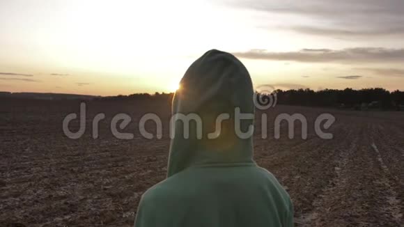 在日落时分在户外的野外散步的头罩男孩视频的预览图