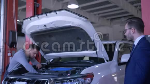 专业的汽车维修技术人员正在用敞篷汽车修理车辆车主表现出积极的服务姿态视频的预览图