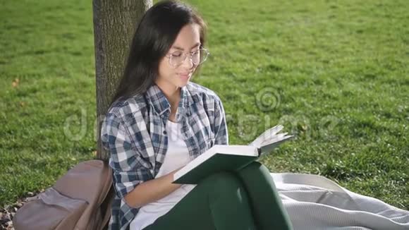 漂亮开朗的女孩正在公园看书视频的预览图
