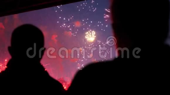 五颜六色的烟花爆炸美丽的近在城市天空前面的人4K视频的预览图