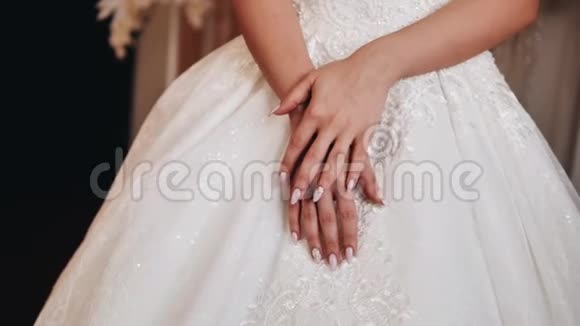 那个女孩把手叠在她白色连衣裙的下摆上快关门结婚视频的预览图