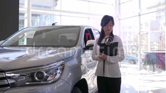 车展微笑汽车销售商的肖像亚洲妇女在经销商处展示新汽车视频的预览图