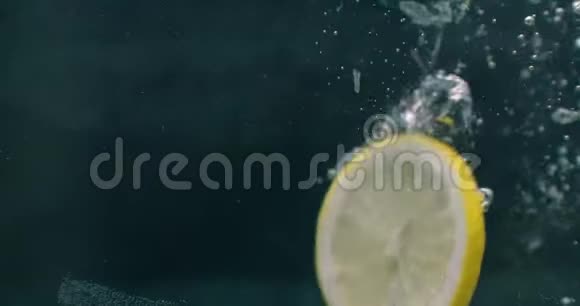 几个柠檬水果掉进水箱里扰乱了水三个亮黄色柠檬水果倒在水里视频的预览图