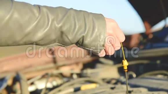 路上的女孩检查发动机的油位女孩的手伸到油尺检查视频的预览图