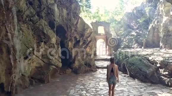 背面的女孩在石拱上留下洞穴与光线相对视频的预览图