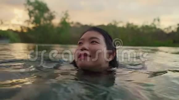 假日生活方式拍摄于年轻美丽和放松的亚洲女性在热带度假游泳池欣赏风景视频的预览图