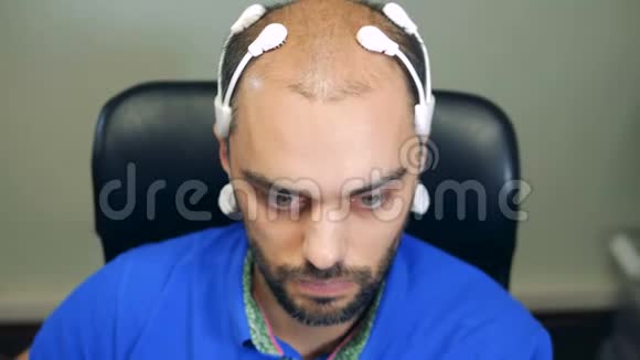 一名男子头上戴着机器人脑电波扫描传感器特写视频的预览图