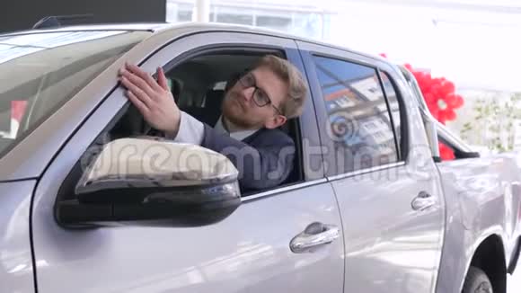 快乐购车者顾客享受新汽车的画像展示了坐在机舱里透过窗户看车的钥匙视频的预览图