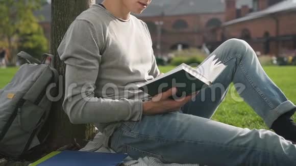 年轻放松的家伙正坐在格子呢学院读现代小说视频的预览图