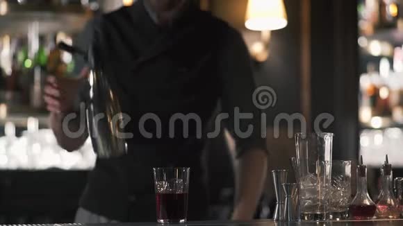 希普斯特酒保使用摇床和制作酒精鸡尾酒在美丽的现代酒吧慢动作视频的预览图