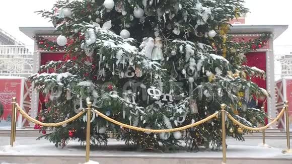 镜头从下到上移动重点放在覆盖着雪和美丽装饰的大圣诞树上视频的预览图