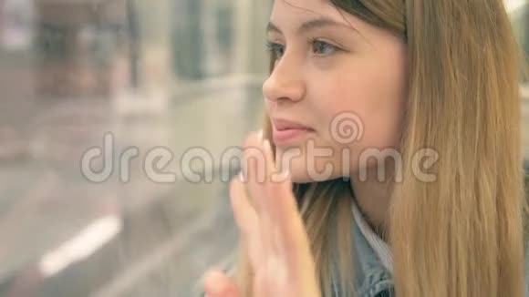 地铁中的女人挥手告别悲伤把头靠在窗前视频的预览图