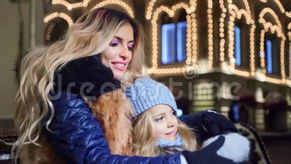 幸福的家庭母亲和小女儿拥抱户外照明灯背景视频的预览图